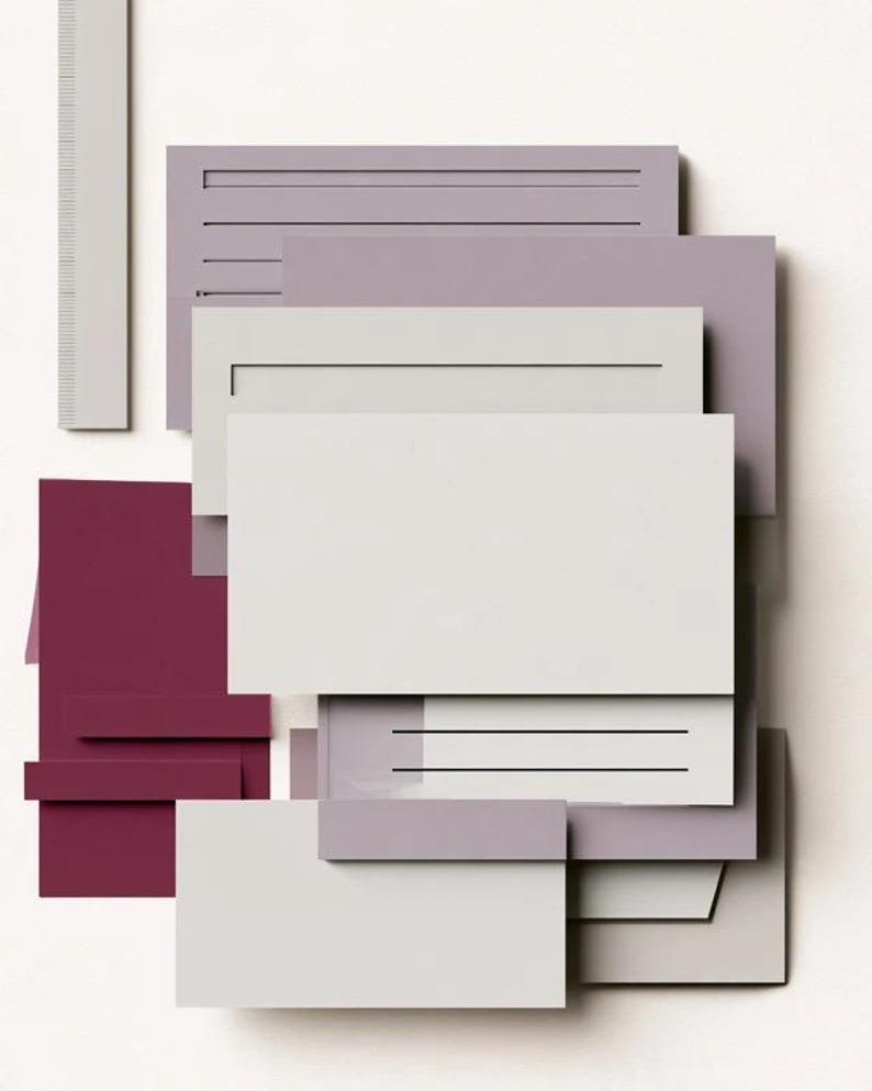 Layered unprinted menu-card mockups with curved paper edges in cream and muted burgundy tones. The arrangement shows contrasting paper shapes and soft shadows for a modern table-stationery design.