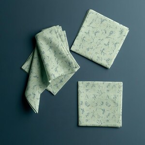Square cocktail-napkin and paper-detail mockups with fine botanical line illustrations, styled with coordinating paper pieces. Digital presentation of a custom illustrated wedding and event design.