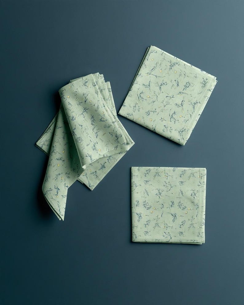 Square cocktail-napkin and paper-detail mockups with fine botanical line illustrations, styled with coordinating paper pieces. Digital presentation of a custom illustrated wedding and event design.