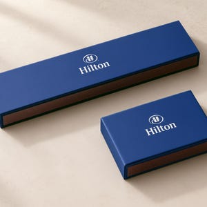Concept mockup of blue matchboxes in 28cm and 14.5cm formats, featuring white Hilton branding.
