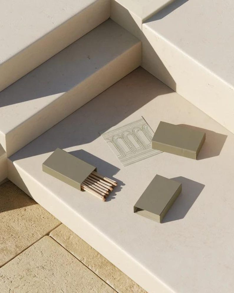 Cream rectangular drawer-style matchbox mockups arranged with coordinating neutral paper samples. The presentation shows sleeves, trays and the compact box proportions for bespoke event designs.