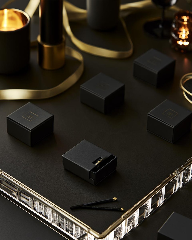 Dark matchbox mockups styled for an evening celebration, with plain and gold-toned decorative sleeve designs. The presentation shows compact rectangular boxes for personalised party favours.