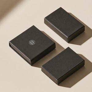 Contemporary matchbox mockup with a coloured paper sleeve and a clean graphic layout. The rectangular box is presented in soft directional light as a personalised wedding or event favour concept.