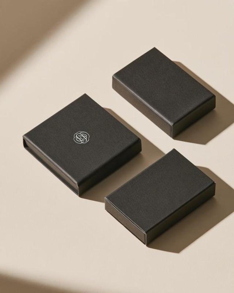 Contemporary matchbox mockup with a coloured paper sleeve and a clean graphic layout. The rectangular box is presented in soft directional light as a personalised wedding or event favour concept.