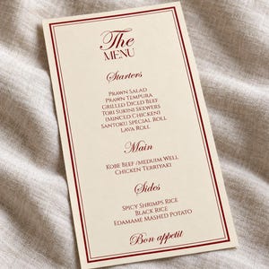 Może przedstawiać: Prostokątna karta menu w kolorze kremowym z ciemnoczerwoną obw&oacute;dką z podw&oacute;jnej linii. Tekst zawiera The Menu, Starters, Prawn Salad, Prawn Tempura, Grilled Diced Beef, Tori Sukini Skewers, Santoku Special Roll, Lava Roll, Main, Kobe Beef, Chicken Terriyaki, Sides, Spicy Shrimps Rice, Black Rice, Edamame Mashed Potato oraz Bon appetit.