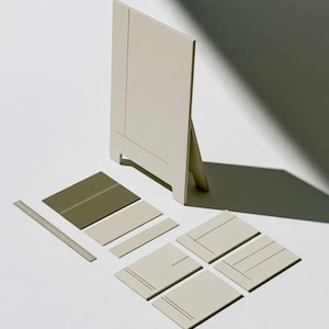 A tall cream wedding-sign mockup displayed upright with coordinated cream and olive paper stationery on a neutral surface. Soft daylight highlights the simple rectangular layout and paper textures.