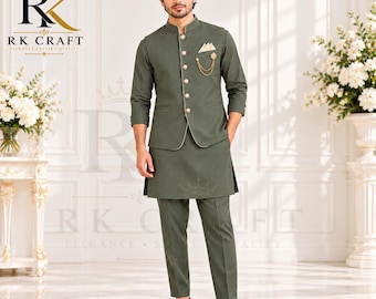 May include: An olive green kurta set featuring a long-sleeved tunic, matching trousers, and a button-front Nehru jacket. The jacket includes a pocket square, a gold-toned chain brooch, and metallic buttons. The ensemble is paired with brown leather shoes.