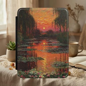 Könnte beinhalten: Eine rechteckige E-Reader-Hülle mit einem strukturierten Druck eines impressionistischen Landschaftsgemäldes. Das Kunstwerk zeigt einen Teich mit Seerosen bei Sonnenuntergang in leuchtenden Orange-, Rot- und Dunkelgrüntönen, eingerahmt von Trauerweiden.