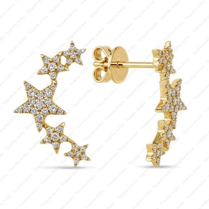 Può includere: Un paio di orecchini a lobo in oro con un design curvo a mezzaluna decorato con molteplici motivi a forma di stella. Ogni stella è incastonata con piccole pietre trasparenti in pavé. Gli orecchini includono un perno standard e chiusura a farfalla.