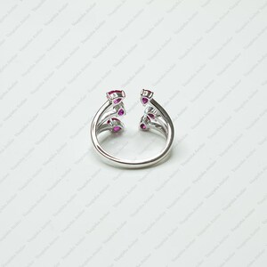 Peut inclure: Une bague ouverte argent&eacute;e orn&eacute;e de trois pierres rose fonc&eacute; en forme de poire de chaque c&ocirc;t&eacute;. L'anneau est lisse et poli, avec les pierres dispos&eacute;es verticalement le long des deux extr&eacute;mit&eacute;s du design ouvert, cr&eacute;ant un aspect sym&eacute;trique.