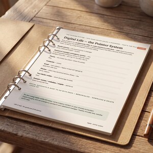 May include: A ring-bound planner page titled Digital Life - the Pointer System, featuring printed sections for recording digital account information, emergency access details, and legacy contacts, accompanied by a wooden fountain pen.