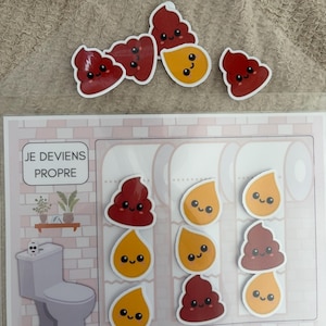 Op de afbeelding: Een zindelijkheidstraining-kaart met de tekst JE DEVIENS PROPRE, een illustratie van een toilet en diverse verwijderbare stickers in de vorm van lachende poepjes en waterdruppels in rood, bruin en geel voor het bijhouden van de voortgang.