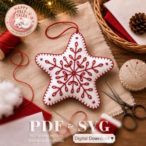May include: A white felt star ornament featuring red embroidered snowflake patterns and a red hanging loop. The star is surrounded by sewing supplies including red thread, a pin cushion, scissors, and white felt fabric pieces.