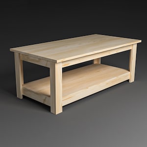 Op de afbeelding: Een rechthoekige, onafgewerkte houten salontafel met een onderste plank. De tafel is gemaakt van lichtgekleurd hout en heeft een eenvoudig, stevig ontwerp. De afmetingen zijn ongeveer 122 cm lang, 61 cm breed en 46 cm hoog.