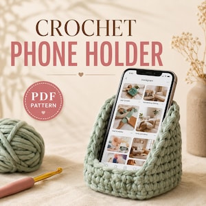 May include: A sage green crochet phone holder with a smartphone resting inside. The text CROCHET PHONE HOLDER and PDF PATTERN are visible. A ball of matching yarn and a gold crochet hook are placed nearby on a neutral fabric surface.