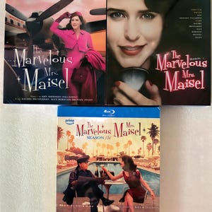 May include: Three Blu-ray disc cases for The Marvelous Mrs. Maisel seasons 3, 4, and 5. The first case shows a person in a pink suit near an airplane. The second case features a close-up portrait. The third case depicts two people by a pool.