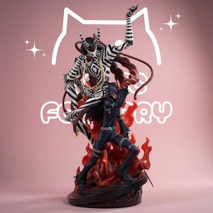 May include: A detailed collectible figurine featuring two characters: one with a black and white striped body and horns, and another in a dark blue suit with red accents, both positioned amidst translucent orange flames on a circular black base.