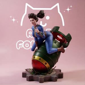 May include: A collectible figurine of a character with dark hair in a ponytail, wearing a blue jumpsuit with a yellow zipper, giving a thumbs up while sitting on a large green and red bomb. The base is a dark gray gear shape on a pink background.