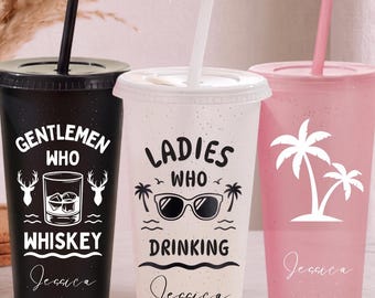 Puede incluir: Tres vasos de plástico con tapa y pajita. El vaso negro muestra un gráfico de vaso de whisky y el texto Gentlemen Who Whiskey. El vaso blanco muestra gafas de sol y el texto Ladies Who Drinking. El vaso rosa presenta un diseño de palmeras.