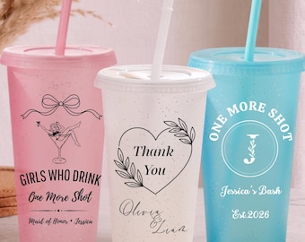 Puede incluir: Tres vasos de plástico con tapas y pajitas en rosa, blanco y azul. El vaso rosa tiene un lazo, una copa de martini y el texto Girls Who Drink One More Shot Maid of Honor Jessica. El blanco tiene un corazón y Thank You Olivia & Liam. El azul dice One More Shot Jessica's Bash Est. 2026.