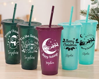 Puede incluir: Cinco vasos de plástico reutilizables con tapas y pajitas en verde oscuro, verde bosque, morado intenso, azul claro y azul cerceta. Cada vaso presenta gráficos navideños en blanco o negro, como muñecos de nieve y el nombre Sophia.