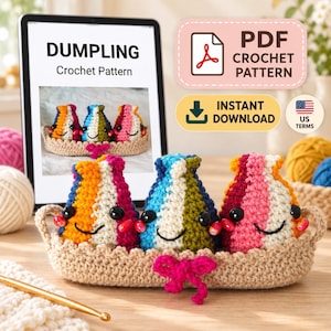Può includere: Tre figure di gnocchi all'uncinetto con occhi neri e sorrisi ricamati, ognuna con strisce verticali arancioni, bianche, rosa, blu, verdi e gialle. Siedono in un cestino all'uncinetto color marrone chiaro con un fiocco rosa. Un tablet mostra il modello PDF.
