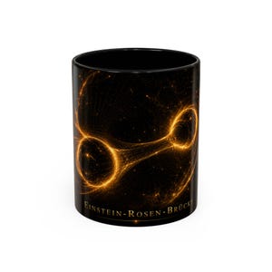 Puede incluir: Una taza de cerámica negra con un gráfico naranja brillante de un puente de Einstein-Rosen, también conocido como agujero de gusano, representado como un túnel de estructura alámbrica que conecta dos puntos circulares. El texto EINSTEIN-ROSEN-BRÜCKE está impreso en oro en la base.