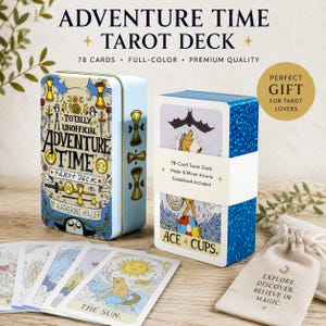 Può includere: Un mazzo di 78 carte dei tarocchi con illustrazioni di Adventure Time. Il set include una scatola di metallo azzurro con disegni, un mazzo avvolto da una fascia bianca Ace of Cups, diverse carte sparse e un sacchetto in tessuto beige.