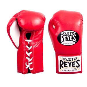Peut inclure: Une paire de gants de boxe rouge vif avec des lacets blancs sur le côté. Les gants présentent le logo noir et blanc Cleto Reyes sur le devant et un écusson rectangulaire avec le texte Cleto Reyes Profesional sur la manchette du poignet.