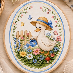 May include: An oval embroidery hoop containing a fabric panel with a printed illustration of a white duck wearing a straw hat and holding a blue watering can. The scene includes a wooden fence, colorful flowers, butterflies, and a mushroom.