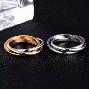 以下が含まれることがあります： ゴールド、ローズゴールド、シルバーのバンドを組み合わせた3色のリングと、ポリッシュ仕上げのシルバーバンド3本で構成されたリングの2つ。どちらも円形で滑らかな金属製の多重バンド構造をした指輪です。