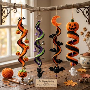 Könnte beinhalten: Ein Set aus vier gehäkelten Halloween-Spiralanhängern, die an einem Ast hängen. Die Spiralen aus orangefarbenem, schwarzem, violettem und grünem Garn sind mit gehäkelten Kürbissen, einem Halbmond, Fledermäusen, einer Katze und einem Geist verziert. Ein Schild trägt die Aufschrift The Happy Stitchery - Set of 4 Artisan Halloween Spirals.