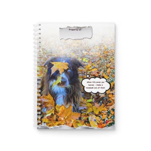 Könnte beinhalten: Ein spiralgebundenes Notizbuch mit einem Foto eines braun-weißen Hundes mit blauen Augen, umgeben von gelben und orangefarbenen Herbstblättern. Das Cover enthält ein Textfeld mit der Aufschrift Property of: und eine Sprechblase mit dem Text When life gives you leaves - make a notebook out of them.