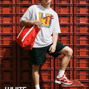 May include: A white short-sleeved t-shirt with a yellow, blue, and red graphic print that reads WTF WHAT THE FUCK, paired with black shorts, a red tote bag with white straps, red-tinted sunglasses, and red and white athletic sneakers with white socks.