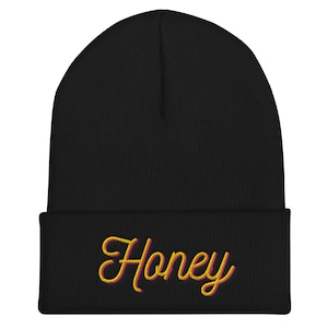May include: Black beanie with a yellow and pink embroidered "Honey" on the front.