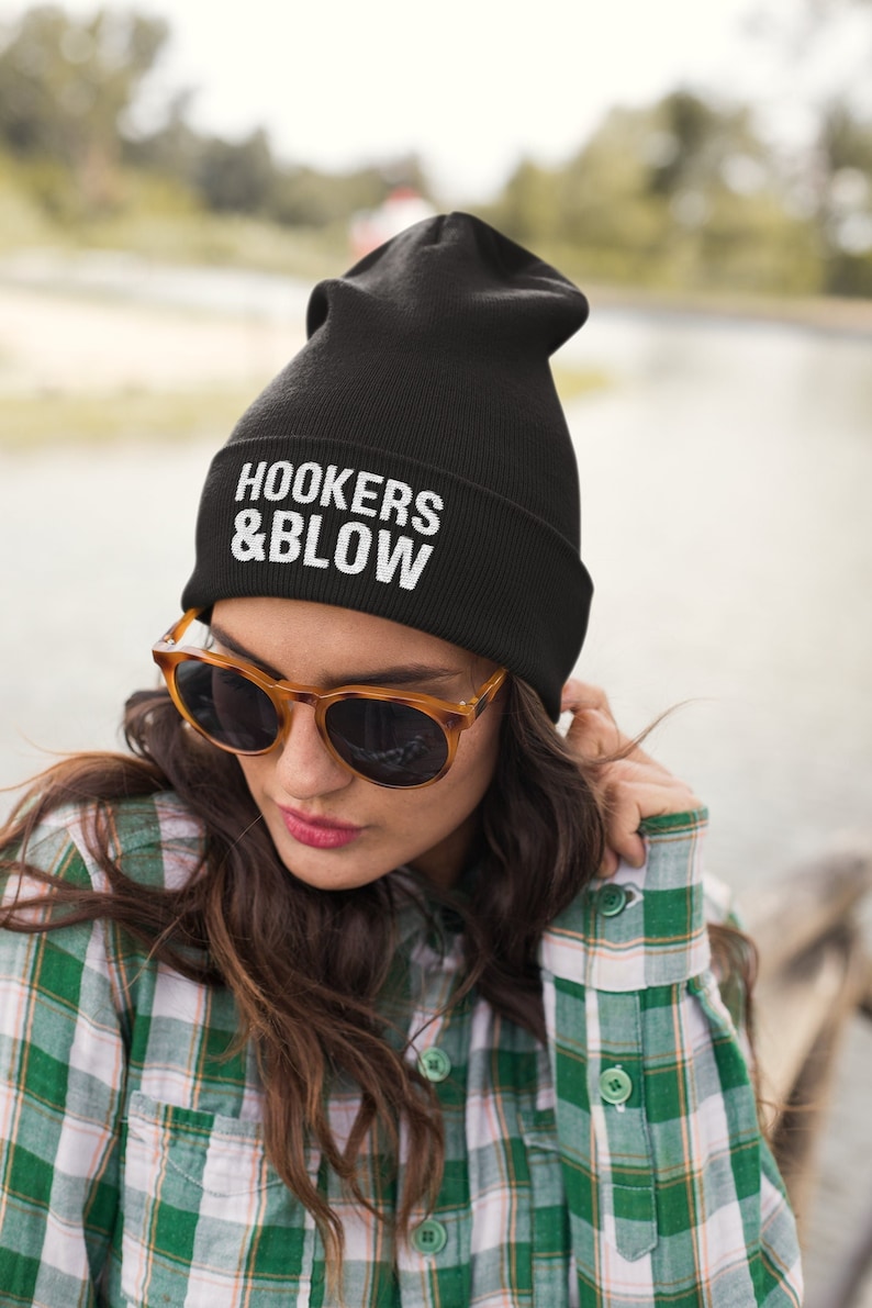 May include: Black beanie with white text that reads "HOOKERS & BLOW".