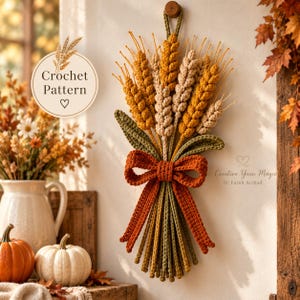 May include: A wall hanging featuring a crocheted wheat sheaf in shades of gold, beige, and green, tied with a burnt orange bow. The text "Crochet Pattern" appears in a circular emblem, and "Creative Yarn Magic by Farah Arshad" is printed below.