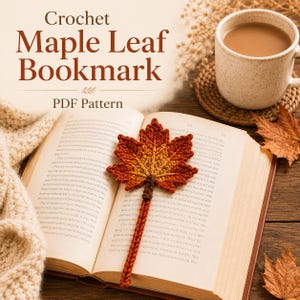 May include: A crochet maple leaf bookmark featuring a gradient of orange, red, and yellow yarn, resting on an open book. The text "Crochet Maple Leaf Bookmark PDF Pattern" is displayed above the bookmark, alongside a mug of coffee.