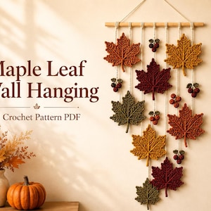 May include: A wall hanging featuring crocheted maple leaves in shades of orange, red, yellow, and green, suspended from a wooden dowel with small crocheted berry clusters. The text reads Maple Leaf Wall Hanging Crochet Pattern PDF.