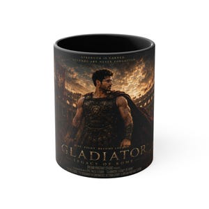 Könnte beinhalten: Ein schwarzer Keramikbecher mit einer Grafik eines Gladiators in Rüstung in einer Arena. Der Text lautet: STRENGTH IS EARNED. LEGENDS ARE NEVER FORGOTTEN. GLADIATOR LEGACY OF ROME. DREAM PORTRAIT STUDIO PRESENTS. EPIC TALES STUDIO.