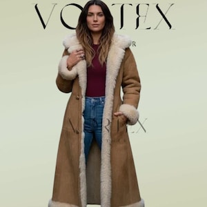 May include: A long tan suede coat featuring a thick cream-colored faux fur lining, a hood, and long sleeves with fur cuffs. The coat is worn over a dark red top and blue denim jeans. The text VORTEX is visible at the top and bottom of the image.