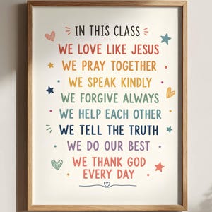 May include: A framed wall art print featuring the text IN THIS CLASS WE LOVE LIKE JESUS, WE PRAY TOGETHER, WE SPEAK KINDLY, WE FORGIVE ALWAYS, WE HELP EACH OTHER, WE TELL THE TRUTH, WE DO OUR BEST, WE THANK GOD EVERY DAY in colourful lettering.