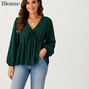Könnte beinhalten: Eine dunkelgrüne Langarm-Bauernbluse mit V-Ausschnitt, Bindeband vorne und gewelltem Saum. Der Text Tie Front Peasant Blouse und 70% Off ist zu sehen. Das Kleidungsstück wird mit einer hellblauen Jeans kombiniert.