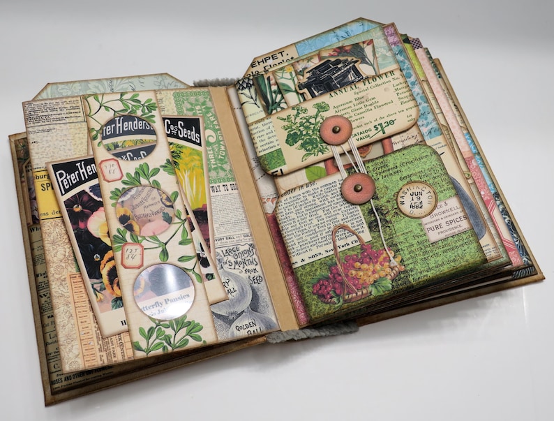 Op de afbeelding: Een vintage-stijl scrapbook met pagina's versierd met botanische illustraties, zaadzakjes en ephemera. De pagina's zijn opengeklapt om een ​​sectie met een knoop en touw te onthullen.