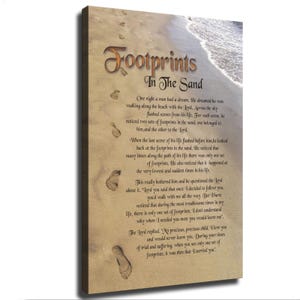 May include: A rectangular canvas wall art piece featuring a sandy beach scene with ocean waves at the top right. The text Footprints In The Sand is printed in large brown letters, followed by the full poem text in black, with footprints in the sand.
