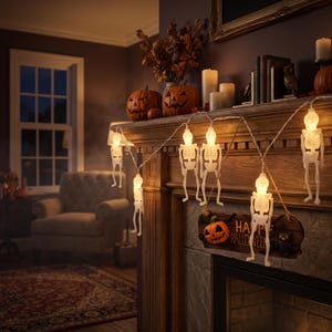 May include: A string of white skeleton-shaped LED lights featuring illuminated skulls and rib cages. The decorative light strand is draped across a wooden fireplace mantel, accompanied by a hanging sign that reads Happy Halloween.