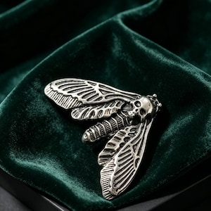 Gemelos con forma de calavera de polilla gótica, accesorio de insecto en tono plata envejecida.