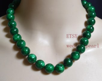 May include: A green jade bead necklace with a dark green color. The necklace is made of round beads and is approximately 18 inches long.