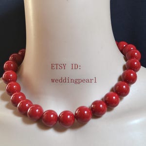 Op de afbeelding: Een rode kralenketting met grote, ronde kralen. De ketting wordt getoond op een mannequin. De tekst "ETSY ID: weddingpearl" is zichtbaar op de mannequin.