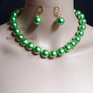 May include: A necklace and matching pair of drop earrings featuring round, glossy, light green pearls. The earrings have gold-toned metal lever-back closures. The text "ETSY ID: weddingpearl" is visible on the left side of the image.